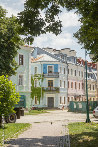 Old houses in Kamianets-Podilskyi city. The picture is framed with the leaves of trees