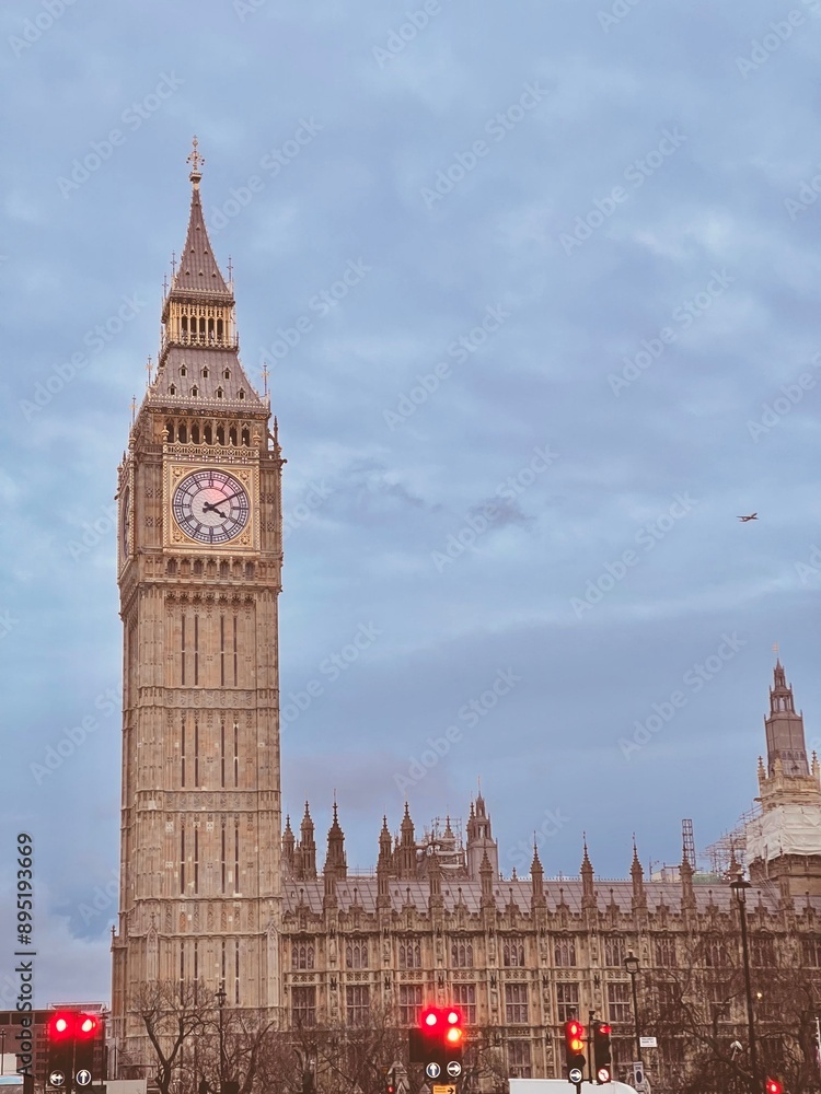 Obraz premium Big Ben towering over London with a cloudy sky backdrop. 