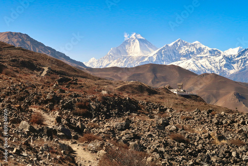 The Guru Rinpoche View Point in the hilly, rocky, dry landscape outside of Muktinath in front of a snow capped mountain range with Dhaulagiri I on the left, Annapurna Circuit Trek, Nepal photo