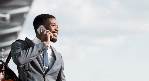 Business Talk. African Man Talking on Phone at Airport and Waiting Taxi