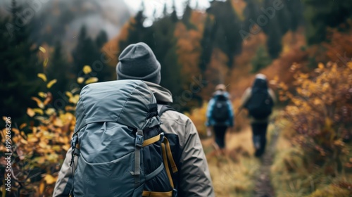 Wallpaper Mural Three hikers equipped with backpacks walk along a forest trail through mountainous terrain surrounded by autumn foliage, capturing the spirit of adventure and nature. Torontodigital.ca