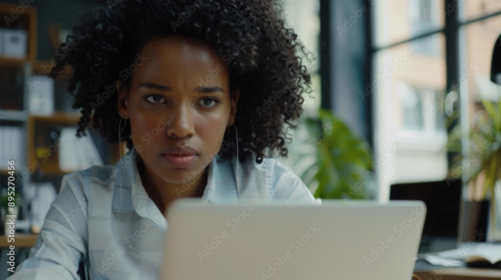 A woman sitting in front of a laptop computer, possibly doing work or online tasks A woman sitting in front of a laptop computer, possibly doing work or online tasks