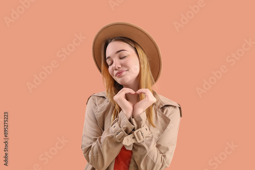 Young woman making heart wi...
