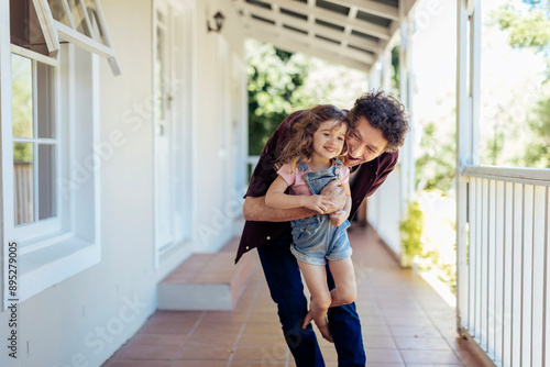 Father playing with daughter on porch photo