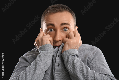 Scared mature man on black ...
