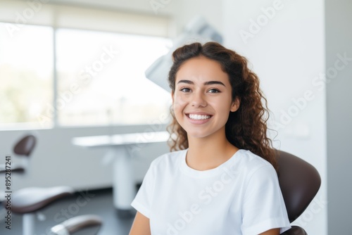 Portrait of a smiling female Hispanic teenage patient at dentist office