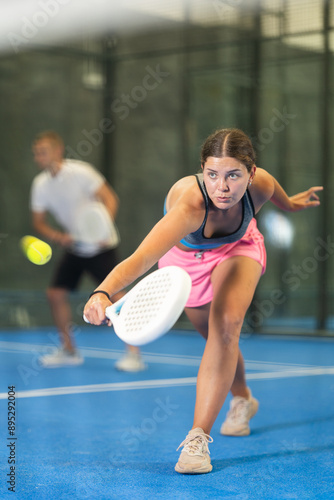 Young woman and young guy in doubles play tennis on tennis court photo