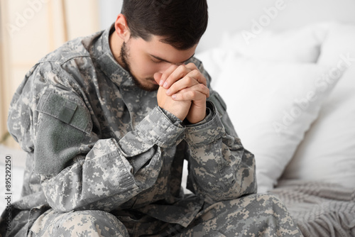 Young male soldier praying ...