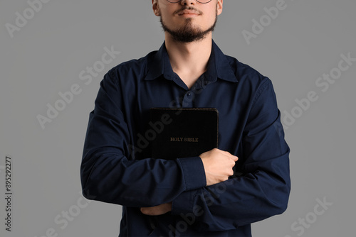 Young man with Bible prayin...