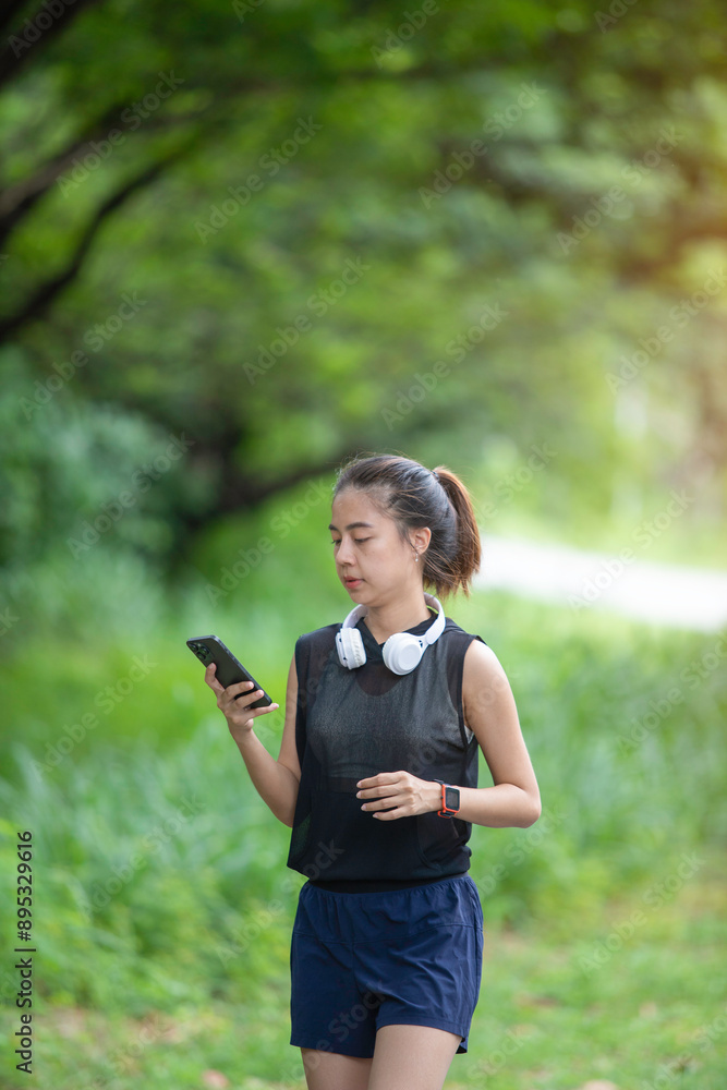 A young woman, enjoying the tranquil ambiance of the public park, scrolls through her phone A young woman, enjoying the tranquil ambiance of the public park, scrolls through her phone