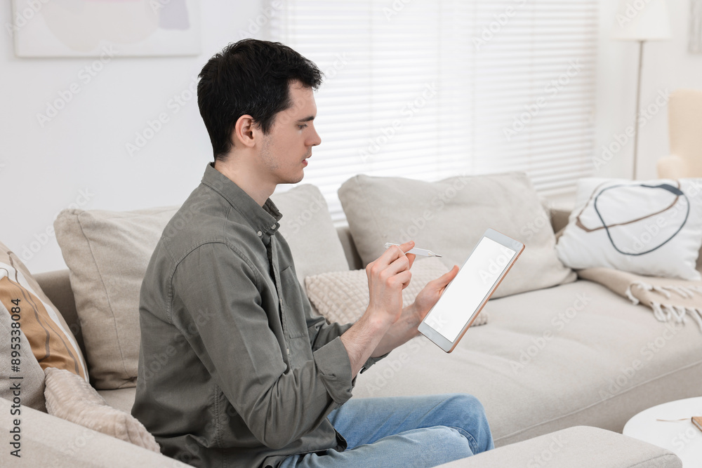 Sick man with thermometer having online consultation with doctor via tablet at home Sick man with thermometer having online consultation with doctor via tablet at home