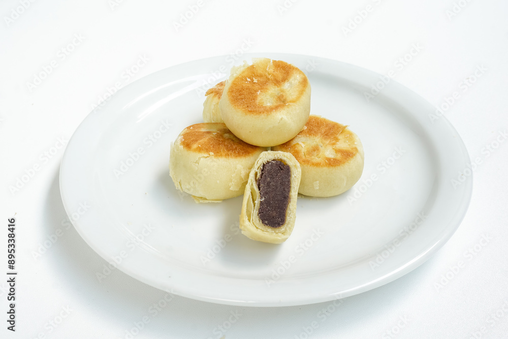 Bakpia, Bakpia Pathok kumbu hitam is a food and souvenir typical of Yogyakarta made from a mixture of red beans coated with flour. Isolated on white Bakpia, Bakpia Pathok kumbu hitam is a food and souvenir typical of Yogyakarta made from a mixture of red beans coated with flour. Isolated on white