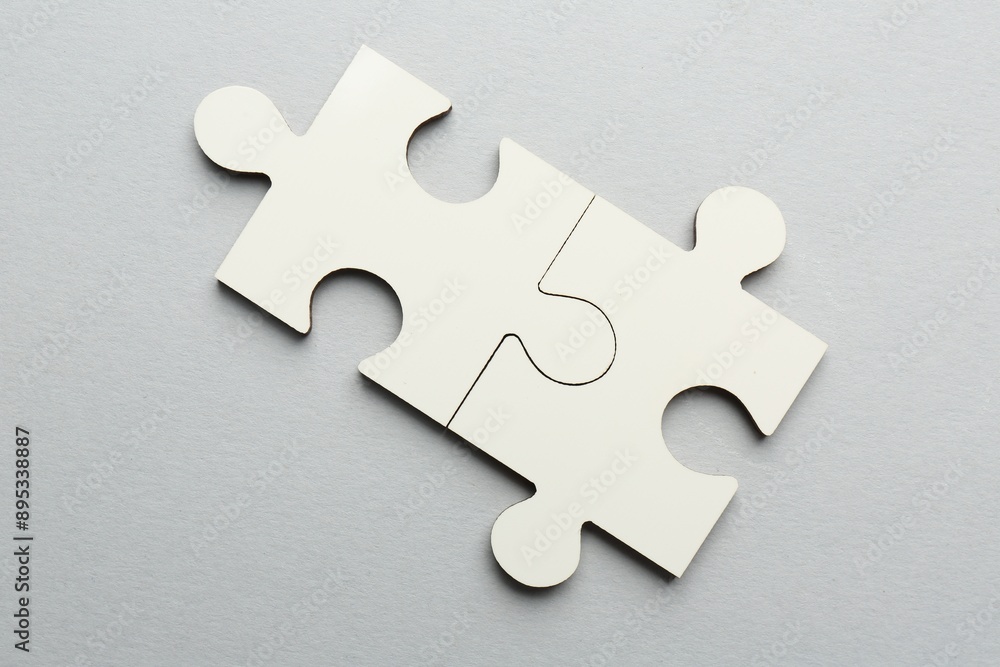 Fototapeta premium White puzzle pieces on grey background, top view
