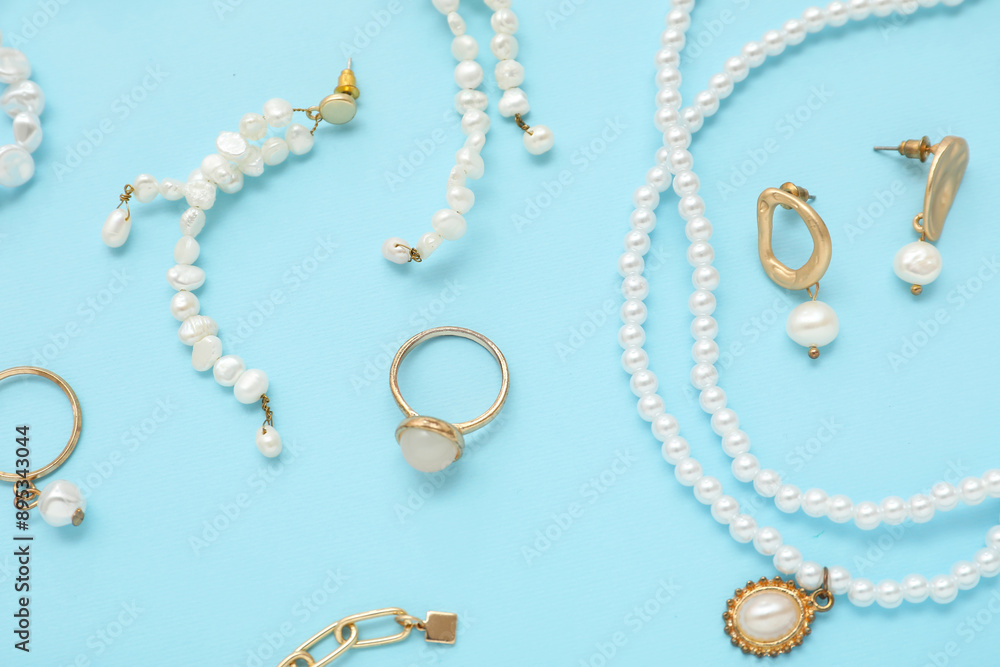 Beautiful pearl jewelry on blue background. Top view Beautiful pearl jewelry on blue background. Top view