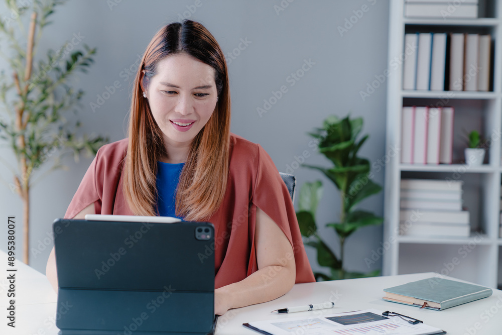 Confident happy young female, business woman leader, professional Asian business woman company manager working on laptop in office sitting at work desk looking at camera, portrait. Confident happy young female, business woman leader, professional Asian business woman company manager working on laptop in office sitting at work desk looking at camera, portrait.