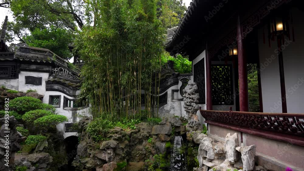 Bamboo trees and small artificial waterfall falling into a pond in Yuyuan Garden, traditional Chinese architecture. Shanghai, China Bamboo trees and small artificial waterfall falling into a pond in Yuyuan Garden, traditional Chinese architecture. Shanghai, China