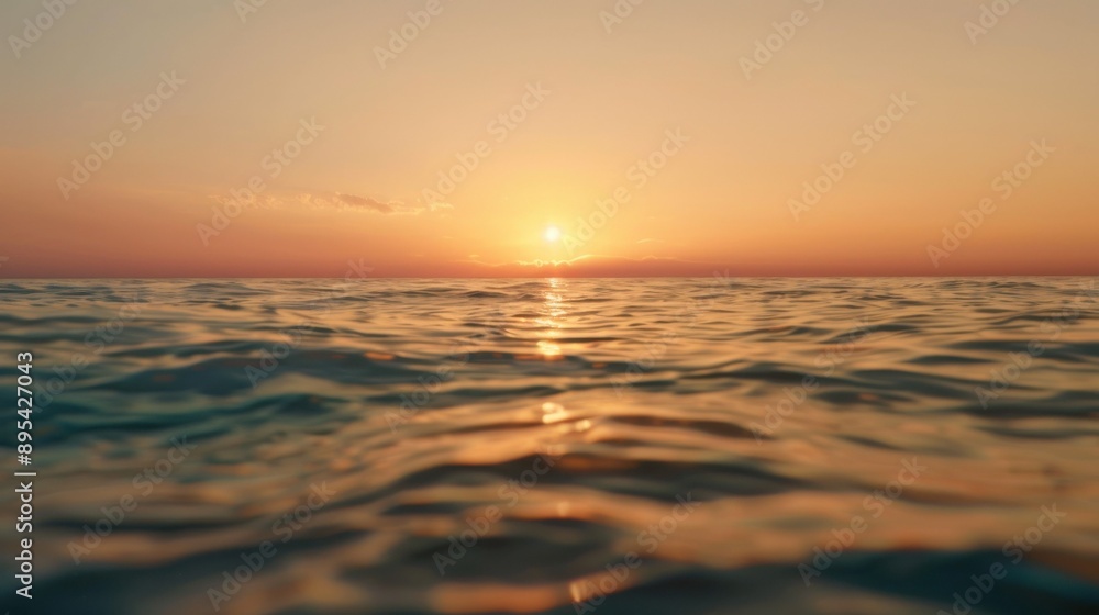 Obraz premium Sunset over the ocean with gentle waves and colorful reflections.