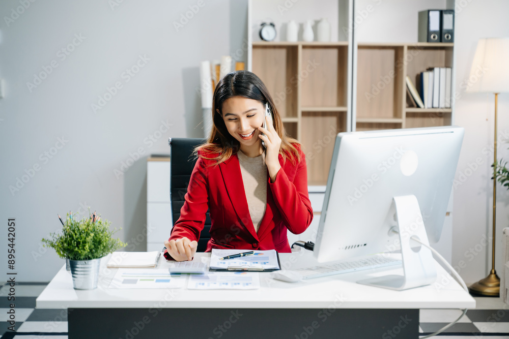 Confident business expert attractive smiling young woman typing laptop and holding digital tablet on desk Confident business expert attractive smiling young woman typing laptop and holding digital tablet on desk