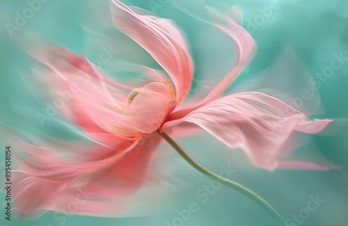 A pink anemone flower with long, flowing petals that seem to dance in the wind motion effect against a soft teal background