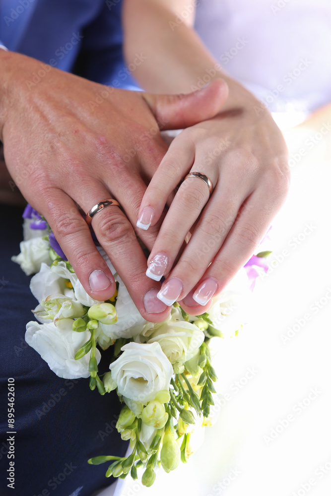 Hands of newlyweds on a bouquet of flowers close-up. Hands of newlyweds on a bouquet of flowers close-up.