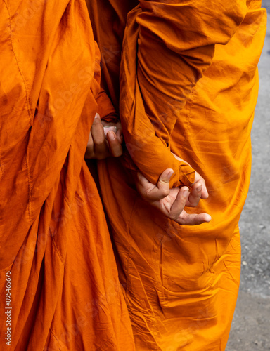 Wallpaper Mural Take the money.  Two monks in orange robes photoraphed from behind in the street in Bangkok.  Only their fingers are visible.  One appears to be passing a roll of money to the other one. Torontodigital.ca