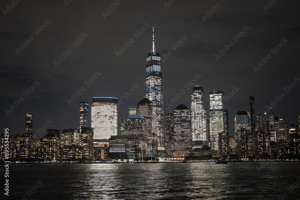 Fototapeta premium Night in The NYC city, USA, United States. Night day with iconic buildings. New York City NYC Manhattan Downtown Skyline, viewed from Jersey City, USA.
