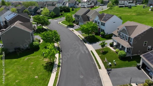 Suburban neighborhood with solar panel houses and curving streets in Pennsylvania. Residential area with green lawns and tree-lined sidewalks. Peaceful community environment aerial. photo