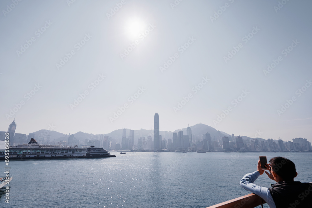 Traveler use smartphone for take photo of Hong Kong harbor. Traveler use smartphone for take photo of Hong Kong harbor.
