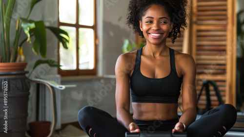 Smiling African American woman enjoying a Pilates session in her home gym, with lots of copy space