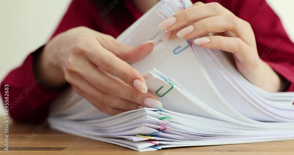 Young woman secretary examines large stack of papers Young woman secretary examines large stack of papers