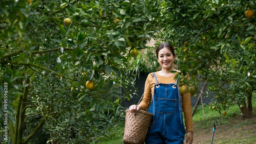 Young Asian woman in denim overalls holding wicker basket, standing in ...