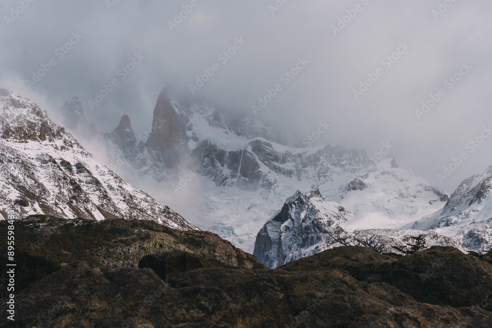 A mountain range covered in snow with a foggy sky. The mountains are tall and majestic, and the snow-covered peaks contrast with the rocky terrain. The foggy sky adds a sense of mystery A mountain range covered in snow with a foggy sky. The mountains are tall and majestic, and the snow-covered peaks contrast with the rocky terrain. The foggy sky adds a sense of mystery
