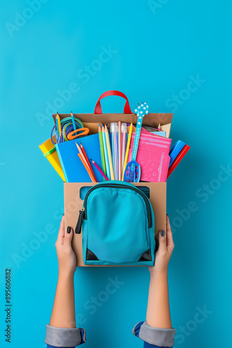 Womens holding donation box with backpack full of school supply for education as a back to school campaign on colorful background