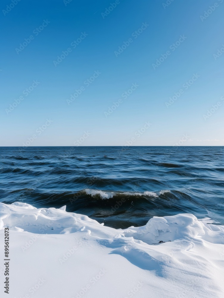 Obraz premium An ocean winter scene with a clear sky captures the serene beauty of the sea during the colder months. 