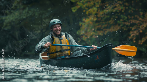 A man joyfully paddles downriver in a canoe, donned in safety gear, surrounded by the lush greenery of a tranquil and scenic waterway.