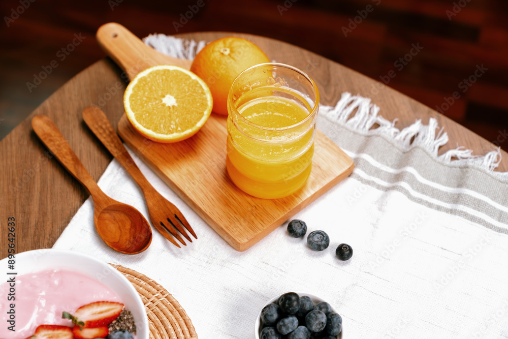 Presenting special drink of fresh orange juice serve with yogurt toppings with berry fruit placing on wood serving decorated. Set of healthy choice at breakfast time for nutrition benefit. Pecuniary. Presenting special drink of fresh orange juice serve with yogurt toppings with berry fruit placing on wood serving decorated. Set of healthy choice at breakfast time for nutrition benefit. Pecuniary.