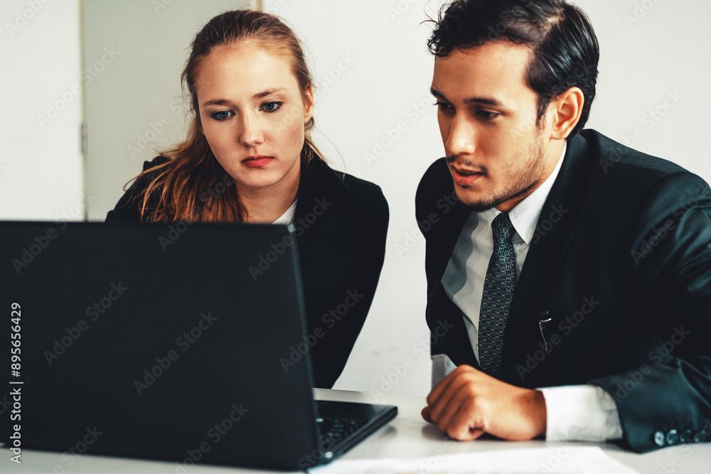 Obraz premium Unhappy serious businessman and businesswoman working using laptop computer on the office desk. Bad business crisis situation and bankruptcy concept. uds