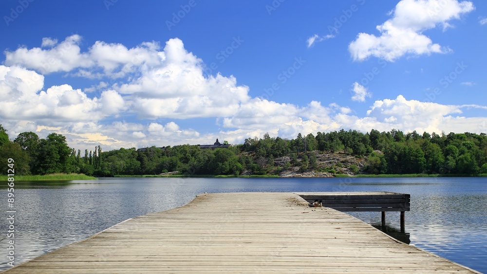 Wooden dock overlooking tranquil bay surrounded by forest at Brunnsviken, Stockholm