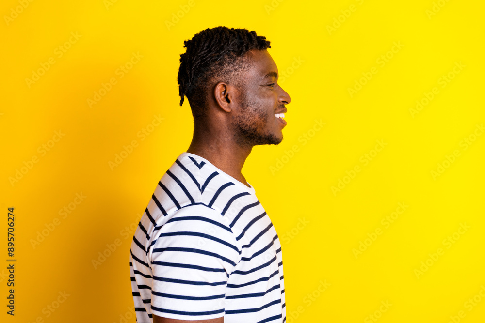 Profile photo of nice young man look empty space wear striped t-shirt isolated on bright yellow color background Profile photo of nice young man look empty space wear striped t-shirt isolated on bright yellow color background