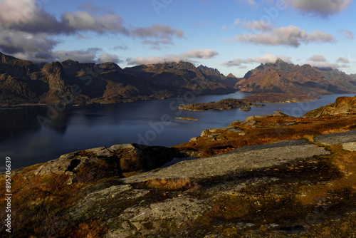 A vast expanse of water surrounded by towering mountains in the background