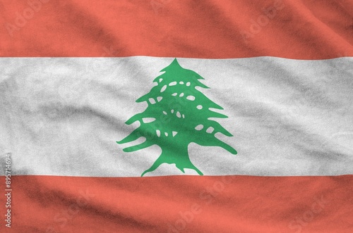 Lebanon flag depicted on folded wavy fabric of old cloth close up photo