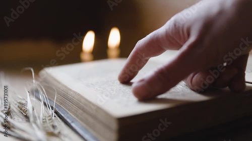 Woman's Hand Following Along in an Old Bible, Burning Candles in the Background, Straws of Rye, Timeless Vintage Period Ambiance, Christian Religion with Bible Studies and Daily Devotionals