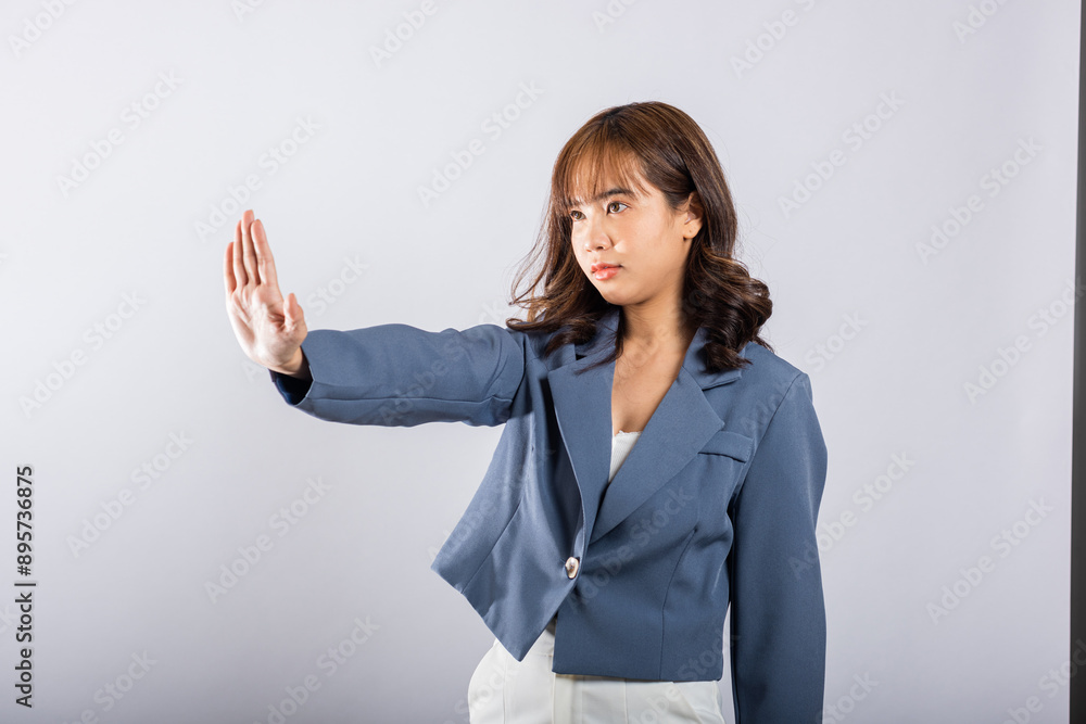 Asian portrait beautiful cute young businesswoman teen smiling doing show stop sign gesture with palm of hand but happy face studio shot isolated on white background, female doubt with copy space Asian portrait beautiful cute young businesswoman teen smiling doing show stop sign gesture with palm of hand but happy face studio shot isolated on white background, female doubt with copy space