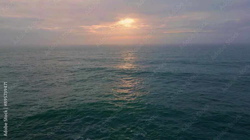 Fototapeta premium Cloudy evening sky ocean water rippling waving in slow motion. Marine horizon