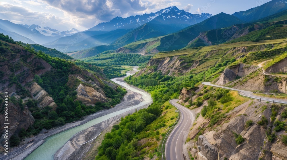 Aerial shot of Svanetia's beautiful road along a river, framed by Alpine peaks and summer greenery Aerial shot of Svanetia's beautiful road along a river, framed by Alpine peaks and summer greenery