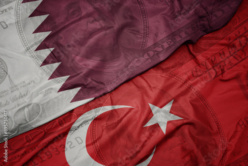 Fototapeta Naklejka Na Ścianę i Meble -  waving colorful flag of qatar and national flag of turkey on the dollar money background. finance concept.