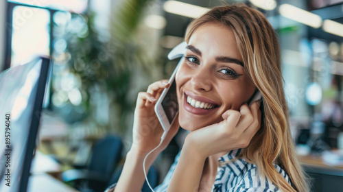 Cheerful businesswoman engaged in a phone call with a coworker in the office