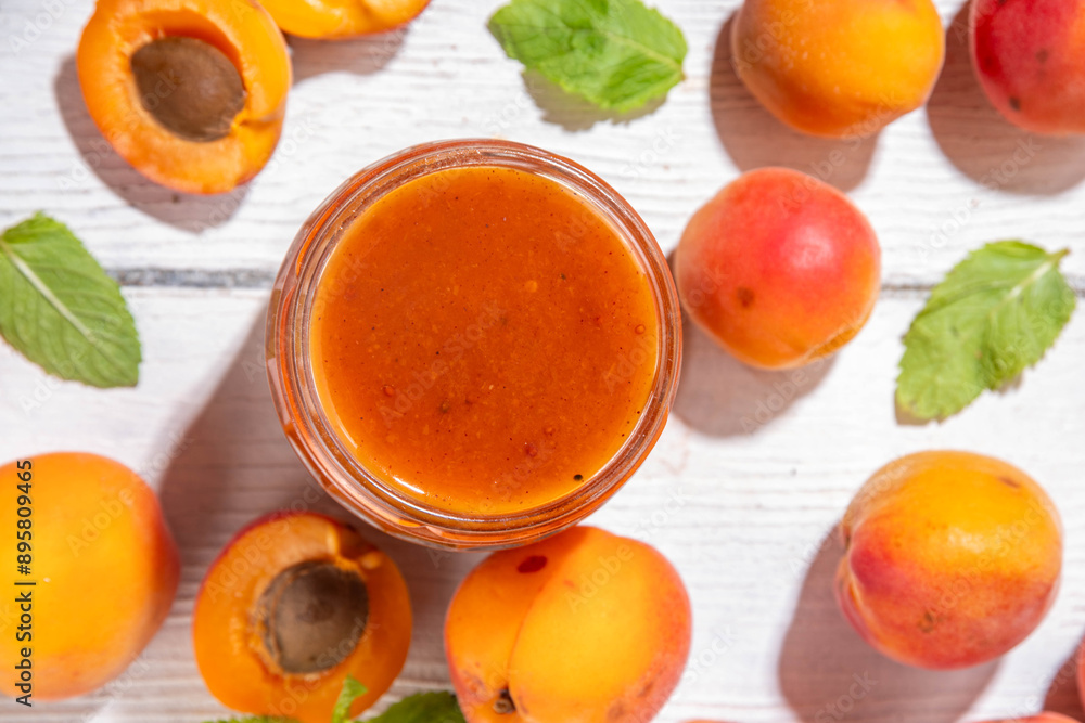 Homemade sweet sour apricot chutney jam preserves with spices and raisins, in small jar, with fresh ripe apricots on white wooden table Homemade sweet sour apricot chutney jam preserves with spices and raisins, in small jar, with fresh ripe apricots on white wooden table