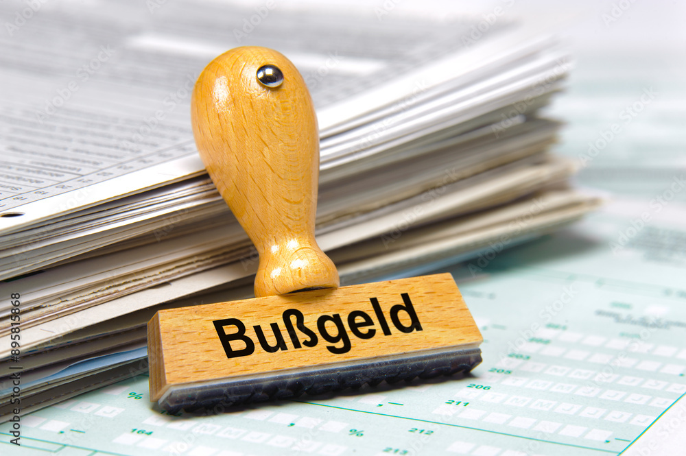 Ein Holzstempel ist beschriftet mit dem Aufdruck: Bußgeld
