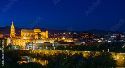 Night panoramic view of the Mosque-Cathedral across the Calahorra Tower and the Roman Bridge over the Guadalquivir River, Cordoba, Andalusia, Spain.